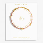 A Littles & Co. Bracelet with 'Be Kind' message on a white background, featuring gold and pink beads. Available at Be Charmed