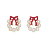 Pair of wreath earrings with red bows and pearl-like centers on a white background. Available at Be Charmed.