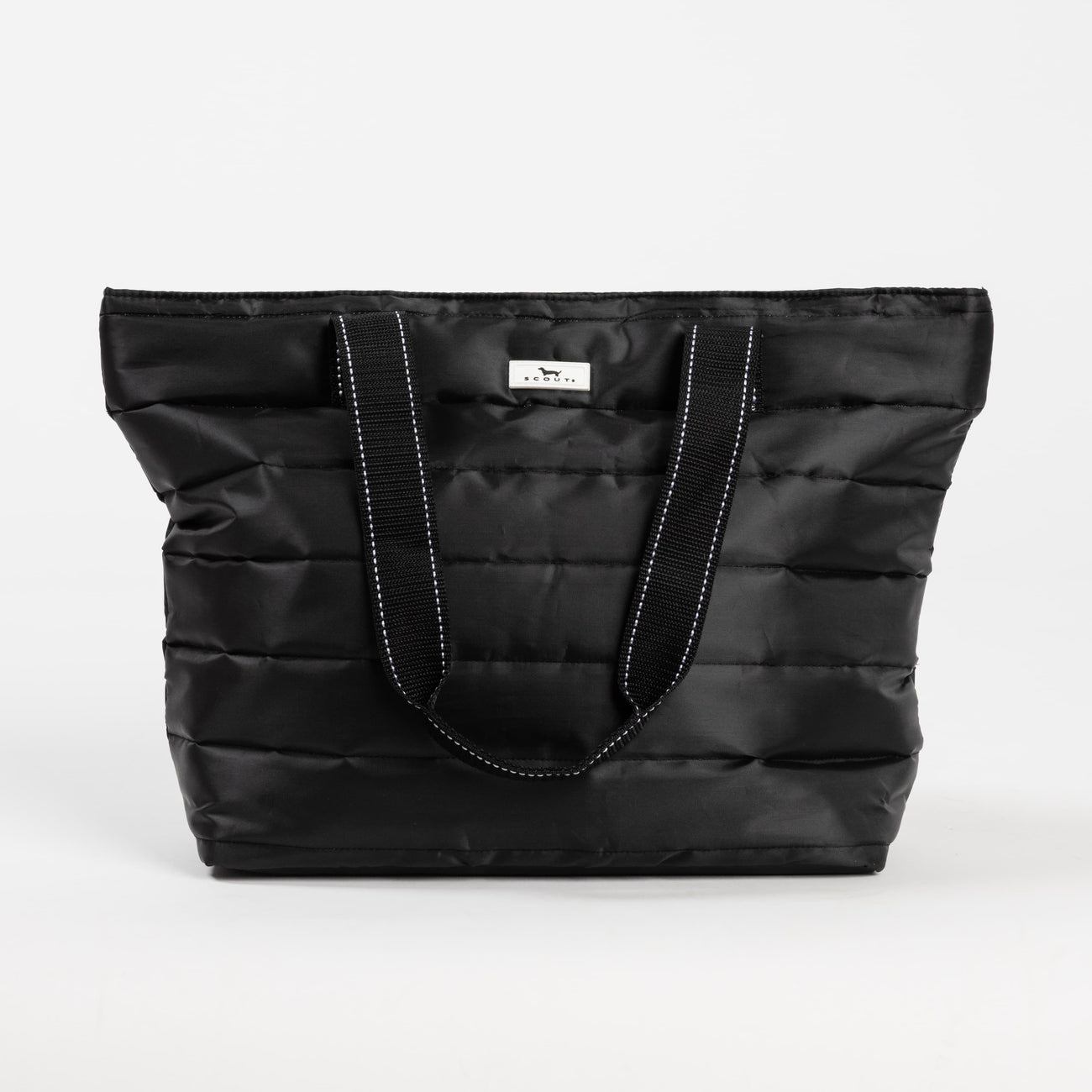 Black Puffer SCOUT Layover Tote – quilted puffer travel tote (19″ W × 13″ H × 5.5″ D), interior zipper compartments, reinforced bottom, folds flat. Available at Be Charmed