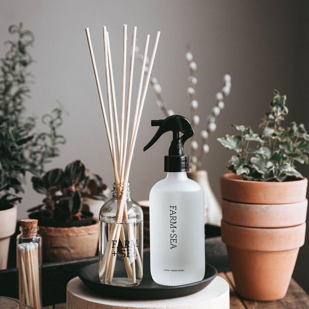 Farm + Sea Peony + Sea Salt 3oz Reed Diffuser on table surrounded by plants