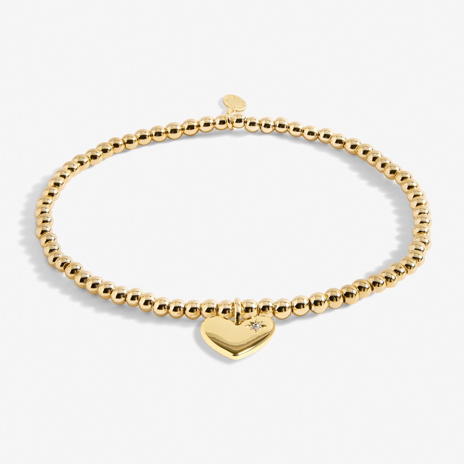 Gold bracelet with a heart-shaped charm on a white background. Available at Be Charmed