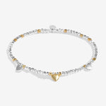 Bracelet with heart charm and clear stones on a white background. Available at Be Charmed