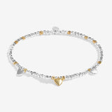 Bracelet with heart charm and clear stones on a white background. Available at Be Charmed