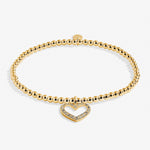 Gold bracelet with a heart-shaped clasp on a white background Available at Be Charmed