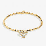 Gold bracelet with a heart-shaped clasp on a white background. Available at Be Charmed