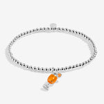 A Little Co Silver bracelet with a small orange charm on a white background. Available at Be Charmed