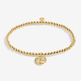 Gold beaded bracelet with a round charm on a white background. Available at Be Charmed