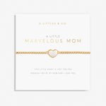 A gold-colored bracelet with a white heart-shaped charm, labeled 'A Littles & Co Marvelous Mom' on a white background. Available at Be Charmed