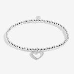 Silver bracelet with a heart-shaped charm on a white background. Available at Be Charmed