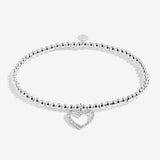 Silver bracelet with a heart-shaped charm on a white background. Available at Be Charmed