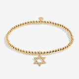 Gold beaded bracelet with a Star of David charm on a white background. Available at Be Charmed