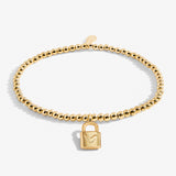A Littles Co Gold beaded bracelet with a lock charm on a white background. Available at Be Charmed