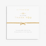 A gold-tone bracelet with a bow-shaped charm, presented on a card with the text 'A Littles & Co. A Little THANK YOU'. Available at Be Charmed