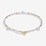 Bracelet with heart-shaped charms on a white background. Available at Be Charmed