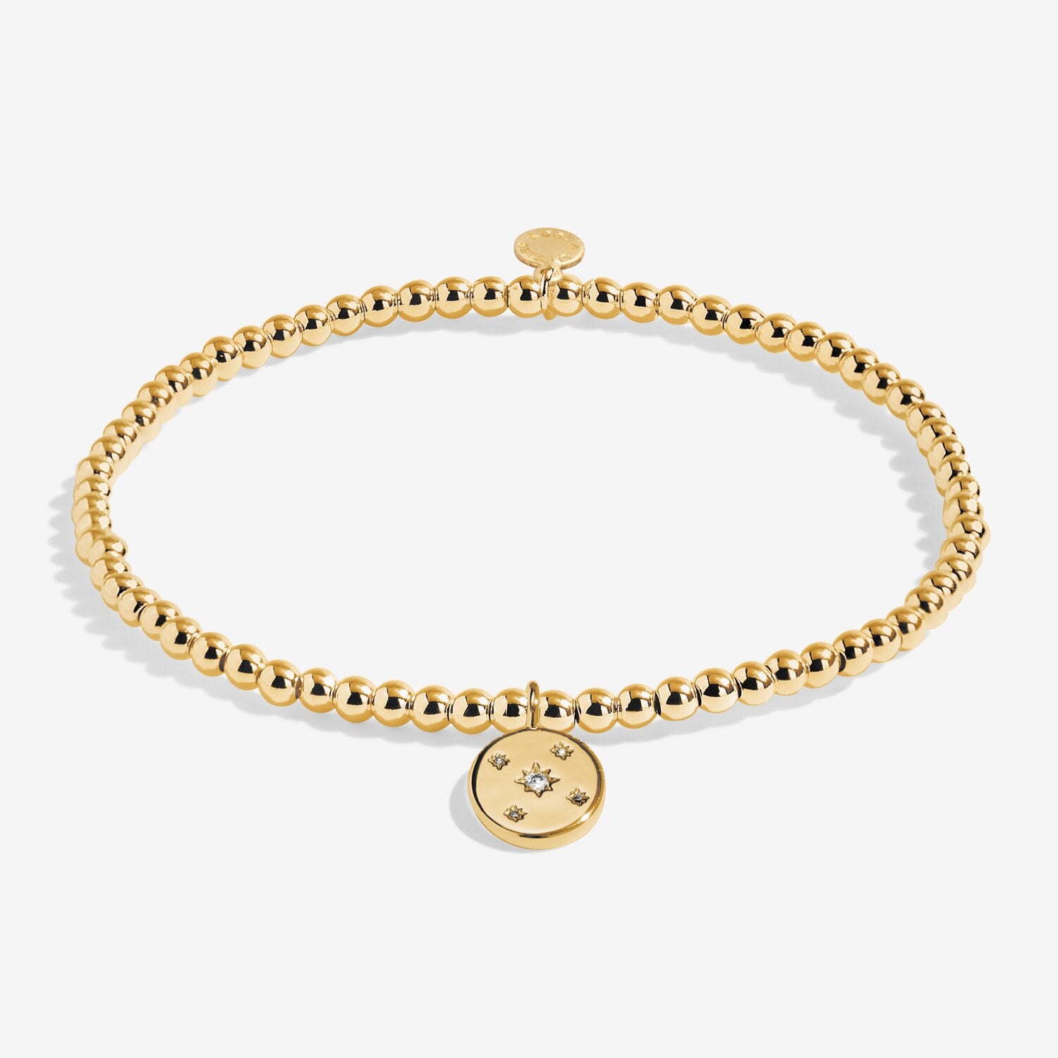 Gold bracelet with a round charm on a white background. Available at Be Charmed