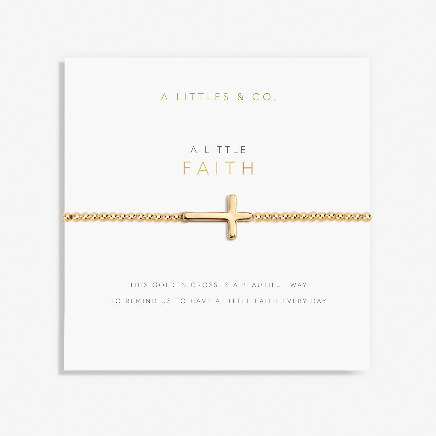 A gold-tone plated bracelet with a cross charm, presented on a card with the text 'A Littles & Co. A LITTLE FAITH. Available at Be Charmed