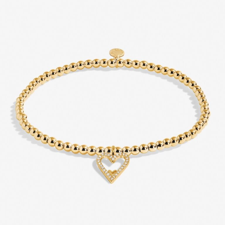 A Littles & Co Gold Happy Birthday Mom Bracelet featuring a delicate gold-plated heart charm on a stretch bead band, a sentimental gift for moms, available at Be Charmed
