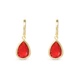 Gold earrings with red teardrop-shaped gemstones on a white background. Available at Be Charmed