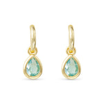 Gold earrings with green teardrop stones on a white background. Available at Be Charmed