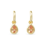 Gold earrings with teardrop-shaped topaz gemstones on a white background. Available at Be Charmed