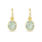 Gold earrings with green gemstones on a white background. Available at Be Charmed