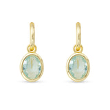 Gold earrings with green gemstones on a white background. Available at Be Charmed