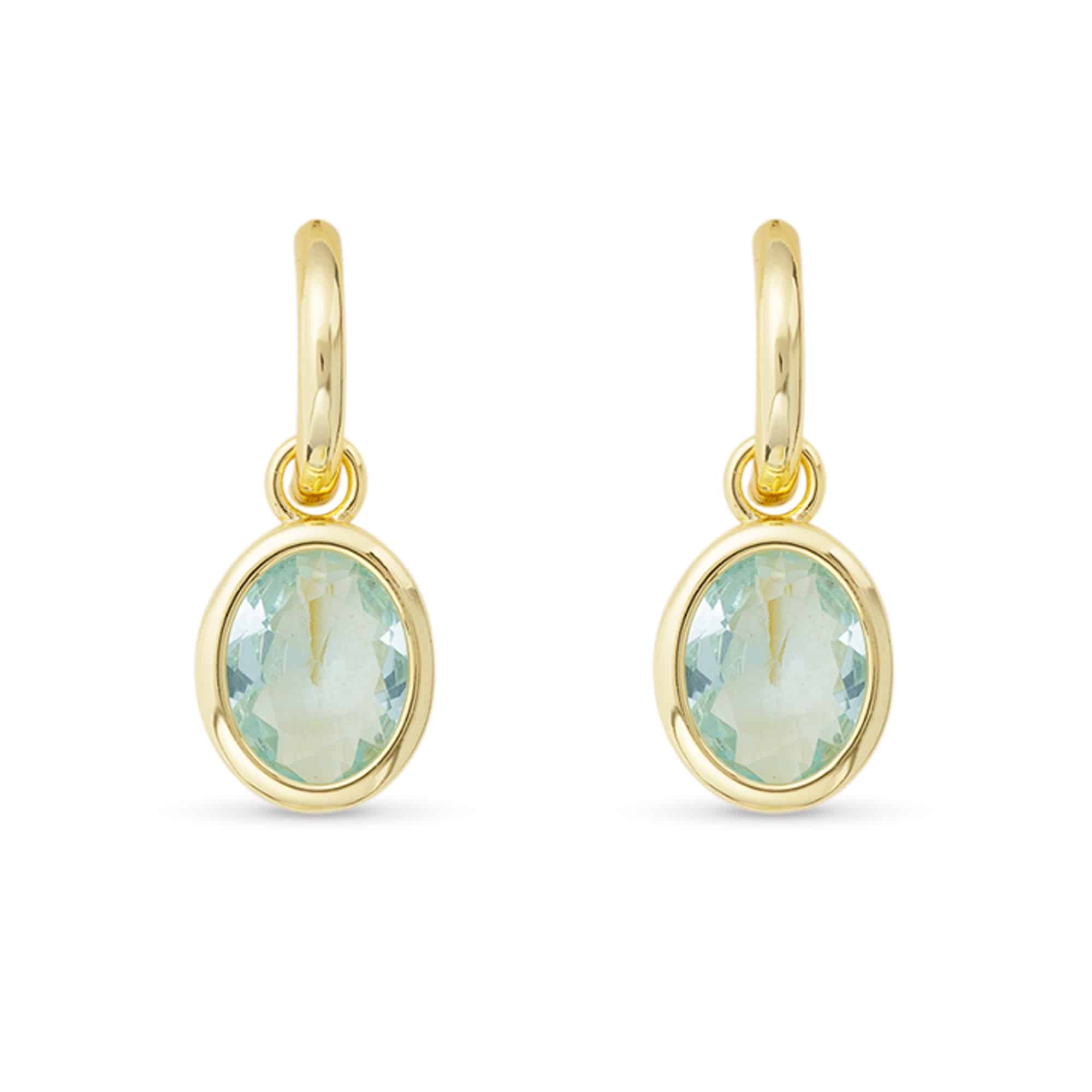 Gold earrings with green gemstones on a white background. Available at Be Charmed