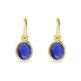 Gold earrings with blue gemstones on a white background. Available at Be Charmed