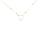 Gold charm necklace with a small round pendant on a white background. Available at Be Charmed