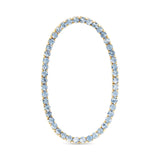 Tennis Bracelet with light blue gemstones and gold accents on a white background. Available at Be Charmed