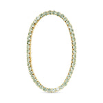 Gold tennis bracelet with light green gemstones on a white background. Available at Be Charmed
