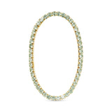 Gold tennis bracelet with light green gemstones on a white background. Available at Be Charmed
