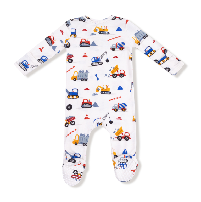 Baby onesie with construction vehicle pattern on a white background. Available at Be Charmed. 