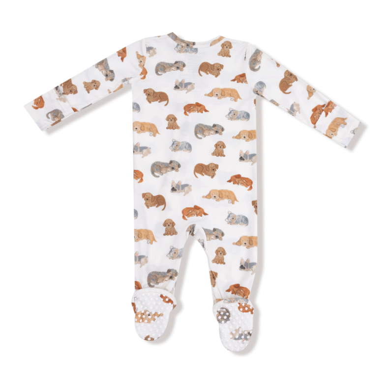 Baby onesie with dog pattern on a white background. Available at Be Charmed.