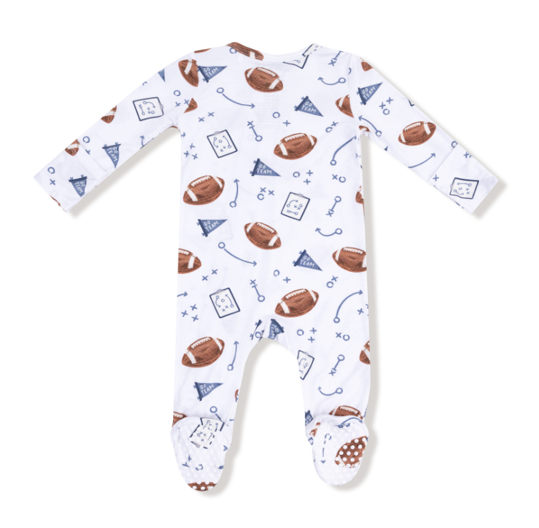 Baby onesie with football pattern on a white background. Available at Be Charmed. 