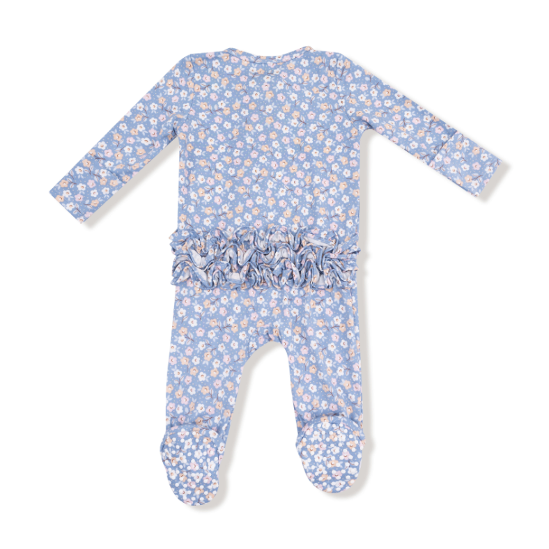 Baby romper with floral pattern and ruffle detail on a white background. Available at Be Charmed. 