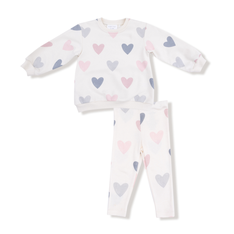 Baby pajama set with heart patterns on a white background. Includes a sweatshirt top and pants. Available at Be Charmed. 
