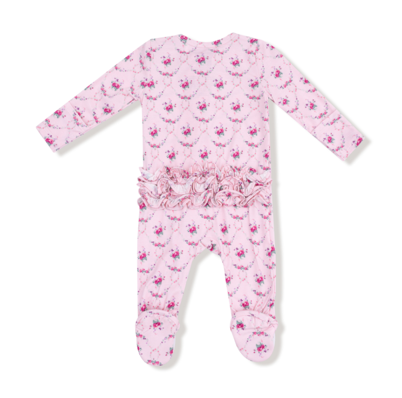 Pink baby onesie with floral pattern on a white background. Available at Be Charmed. 