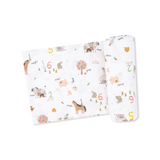 Baby blanket swaddle with farm animals and number pattern on a white background. Available at Be Charmed.  