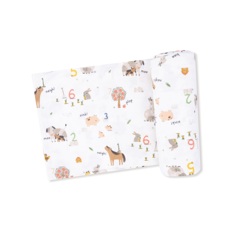 Baby blanket swaddle with farm animals and number pattern on a white background. Available at Be Charmed.  