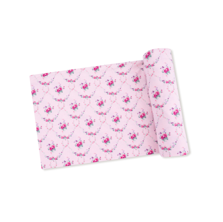 Pink fabric with floral pattern on a white background. Available at Be Charmed.