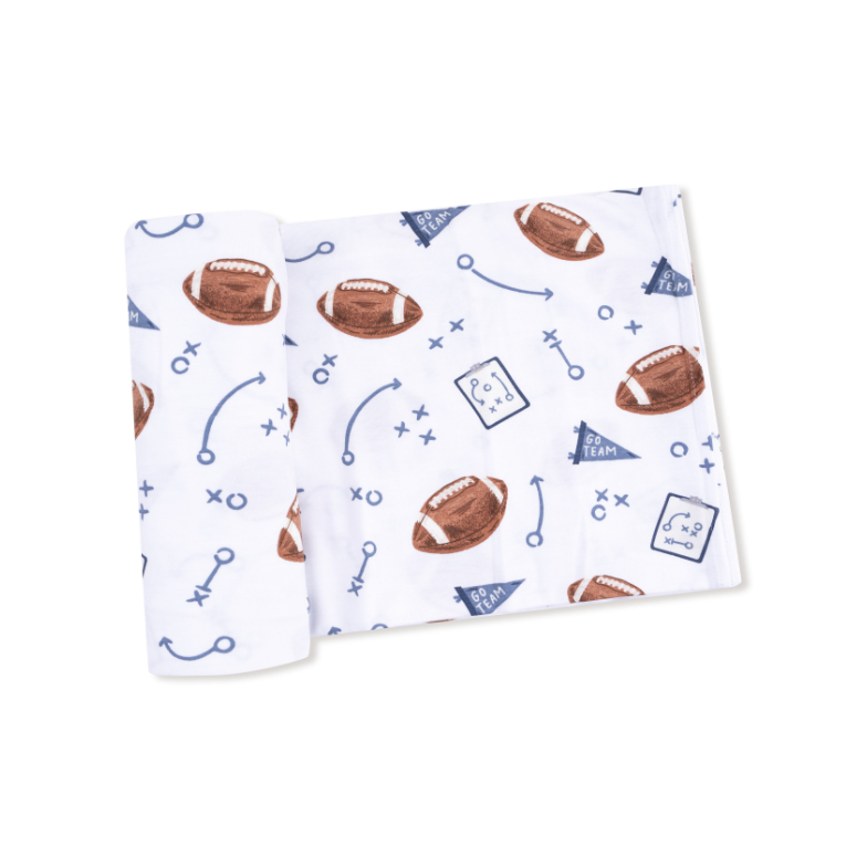 Unfolded baby blanket with football pattern on a white background. Available at Be Charmed. 