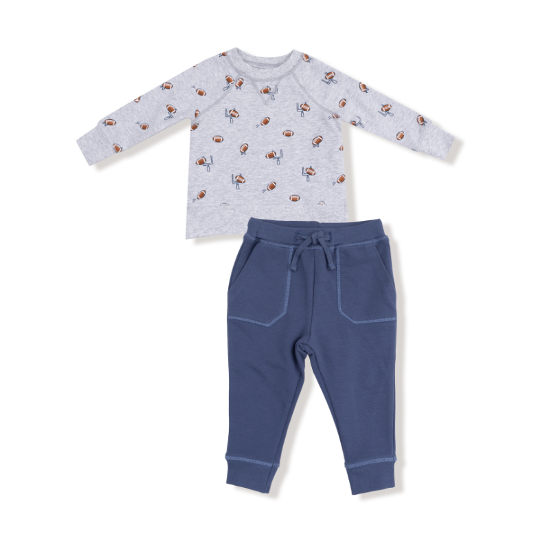 Baby football themed outfit with a long-sleeve shirt and pants on a white background. Available at Be Charmed. 