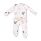 Baby onesie with heart patterns on a white background. Available at Be Charmed. 
