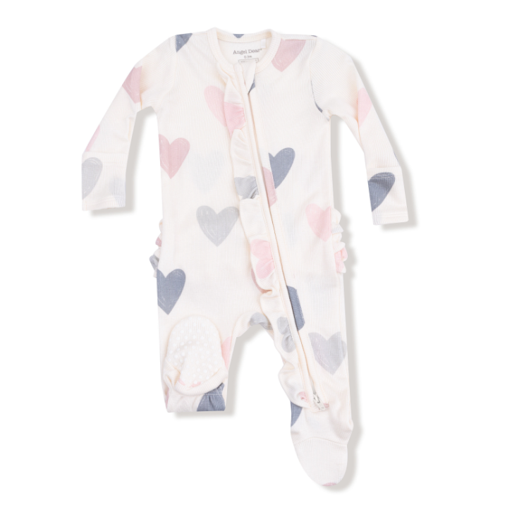 Baby onesie with heart pattern on a white background. Available at Be Charmed. 
