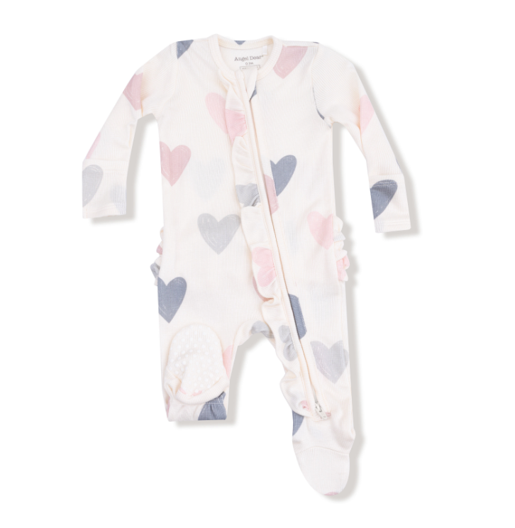 Baby onesie with heart pattern on a white background. Available at Be Charmed. 