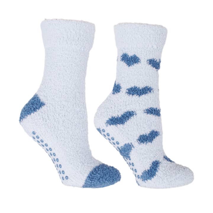 White fuzzy socks with blue heart patterns on a white background. Available at Be Charmed. 