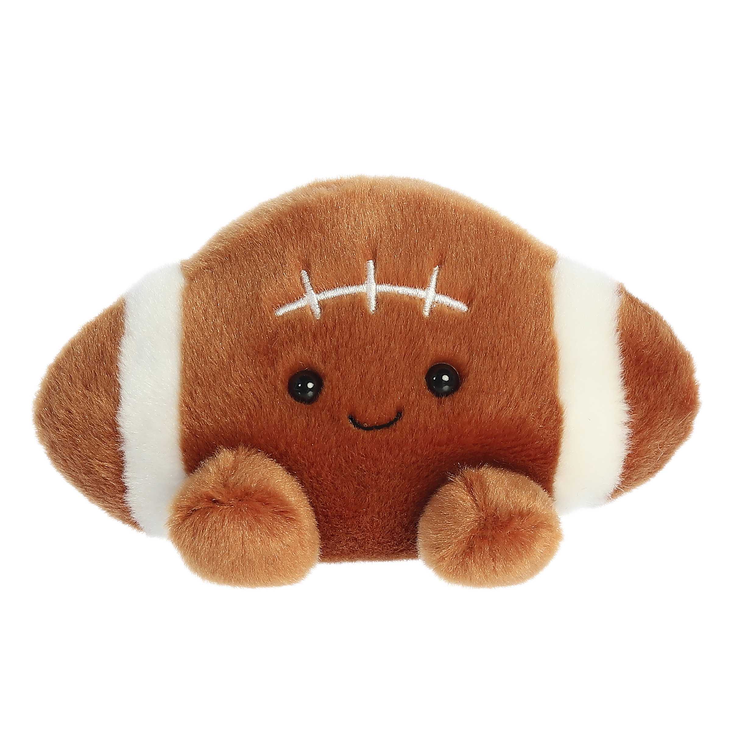 Aurora Palm Pal Tackle Football 5-inch plush toy with brown soft fabric, embroidered white laces, and a cheerful smile. Sporty gift plush. Available at Be Charmed.