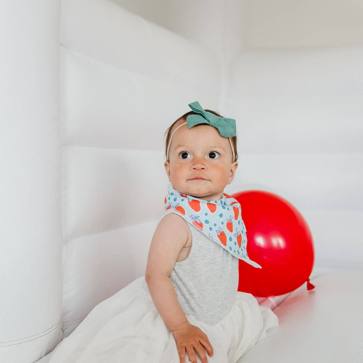 Baby wearing a Copper Pearl Liberty Bandana Bib Set featuring stylish, absorbent bibs for teething babies, available at Be Charmed.