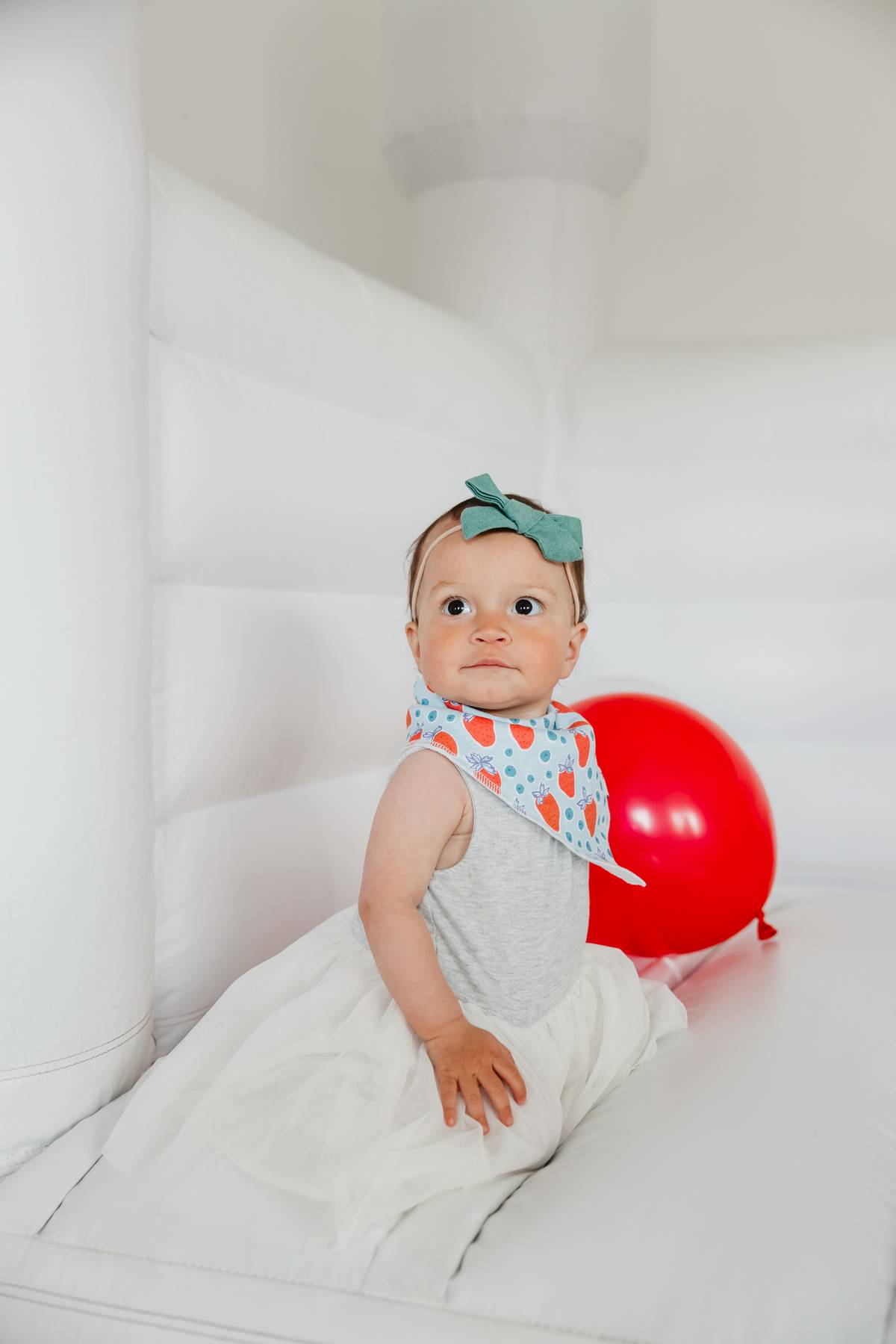 Baby wearing a Copper Pearl Liberty Bandana Bib Set featuring stylish, absorbent bibs for teething babies, available at Be Charmed.